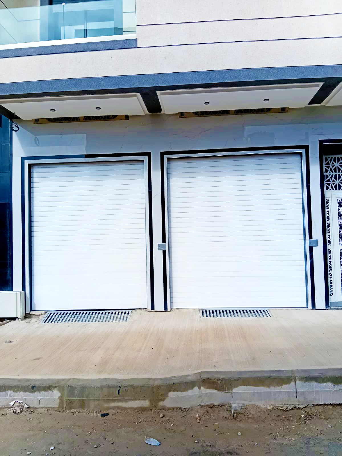 Commercial storefront with rolling shutters in Ahlan.